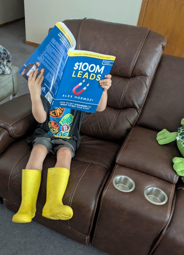 Young boy pretending to read a business book.